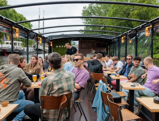 Gezellige groep geniet van een rondvaart met borrelarrangement bij Bootje Speciaal in Groningen.