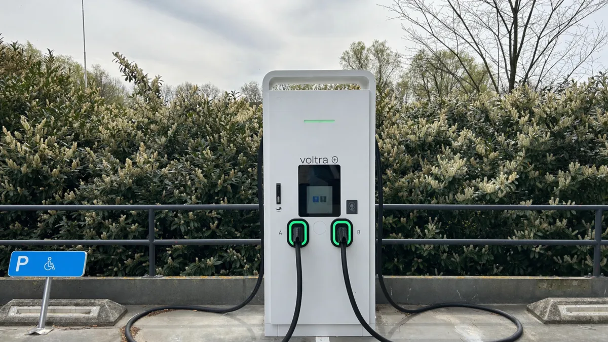 Een Voltra laadpaal met twee aansluitingen voor het gelijktijdig opladen van twee elektrische auto's op een parkeerdek.
