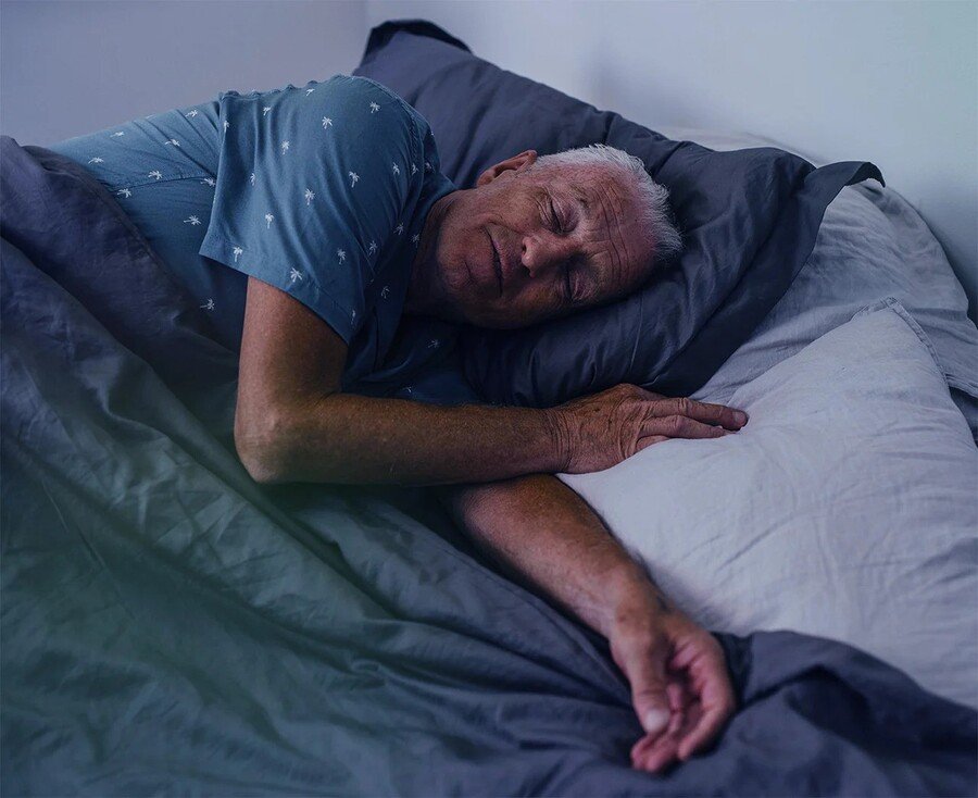 Een man slaapt comfortabel in bed dankzij de snurkoplossingen en slaapproducten van slaapwinkel Rustige Nacht B.V. uit Lent.