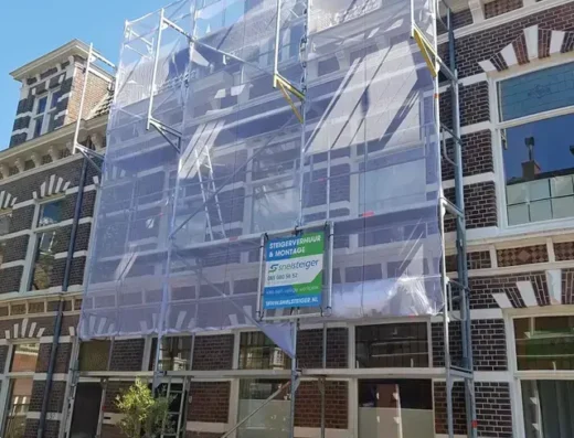 Professioneel opgebouwde gevelsteiger bij een herenhuis met een reclamebord van Snelsteiger aan de voorzijde.